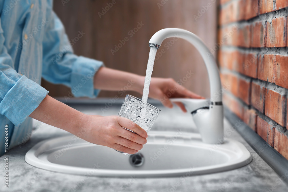 Canvas Prints female hands pouring water in glass cup