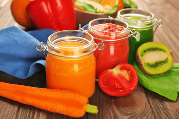 Tasty smoothie drinks with vegetables and fruits on table