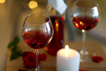 Romantic composition with wine and candle on blurred background