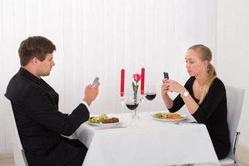 Couple Looking At Their Mobile Phones