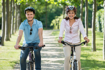 Obraz premium Happy Young Couple Biking In Park