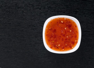 bowl of chili sauce on wood background