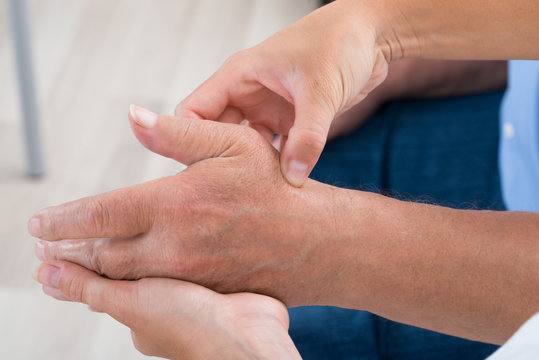 Physiotherapist Massaging Palm Of A Man