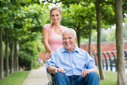 Woman With Her Old Senior Father On Wheelchair