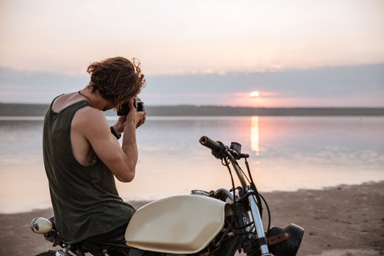 Man making photo with camera while sitting on his motocycle