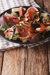 Salad with figs and Parma ham dressed with balsamic sauce. vertical

