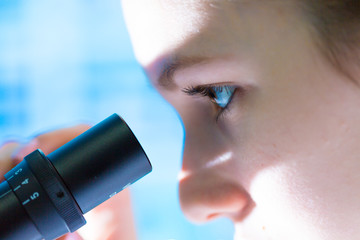 Young woman work microscope in science laboratory