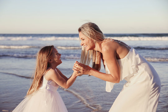 Beautiful mother and daugther laughing together on the beach