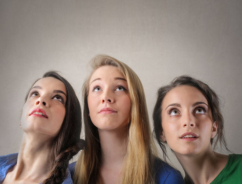 Three beautiful girls looking upwards
