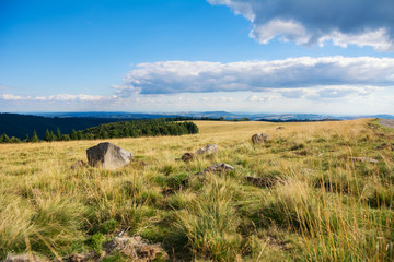 Obraz premium Cloudy sky over mountain landscape and green meadow