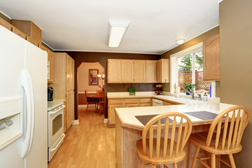 Kitchen room with light brown cobinets and tile counter top.