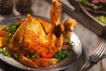 Baked chicken leg, served with roasted potatoes and vegetables.