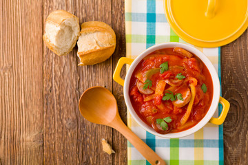 Delicious letcho with fresh vegetables, served in a yellow pot w