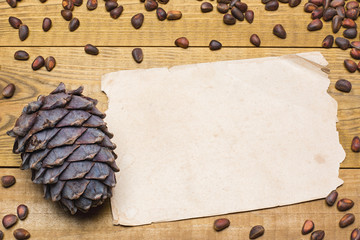 Siberian pine nuts and vintage paper sheet on wooden table