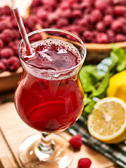 On wooden boards are ice cold red beverage glasses with red raspberry lemon cocktail . Alcohol country cocktail beverage number two hundred ninety six with raspberry bowl and lemon. Top view.