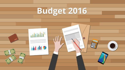 budget 2016 illustration with hand business man work on wooden table with graph and chart and paper document with money
