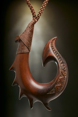 Aus Holz geschnitzter Angelhaken als Maori Symbol Schmuck Anhänger. - obrazy, fototapety, plakaty