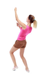 back view of standing girl pulling a rope from the top or cling to something. girl  watching. Rear view people collection.  backside view of person.  Isolated over white background. Sport blond in