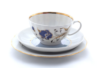 Porcelain cup, plate and saucer on a white background