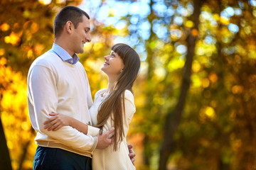 Fototapeta premium Happy man and woman admire each other standing in the autumn par