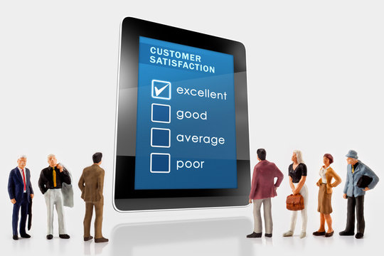Online customer satisfaction survey on a digital tablet, with a group of miniature people in front