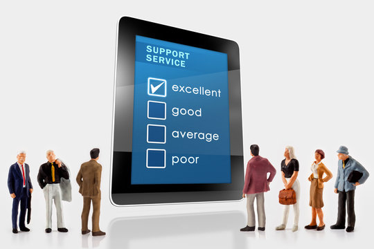 Online support service survey on a digital tablet, with a group of miniature people in front