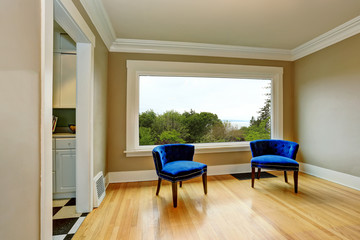 Empty living room interior with blue armchairs and hardwood floor