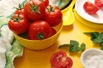 Fresh ripe tomatoes in yellow bowl