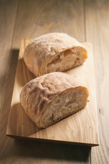 freshly baked ciabatta cut in half on olive board