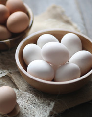 A bowl of egg white,brown on a wooden table.