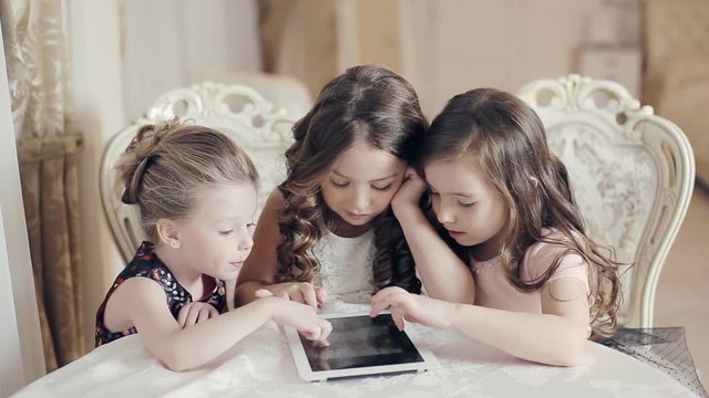 Girls watching photos in the tablet and wonder