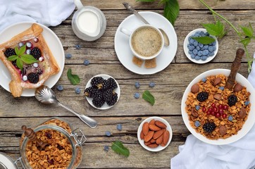 Healthy breakfast with granola, milk, berries, nuts and coffee. Top view.