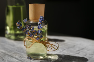 Glass bottle with spa oil and lavender flower, closeup