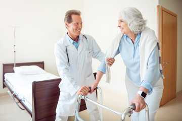 Doctor helping patient at hospital ward