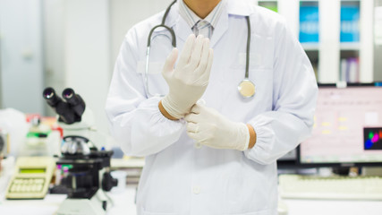 The doctor wearing the rubber gloves for prevent contamination before working. Picture for concept such as hospital, medical, health and science.