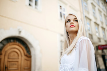 Stunning blonde with tender peach lips looks up in the air