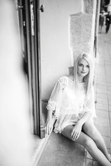 Naklejka premium Black and white portrait of beautiful woman sitting on the road