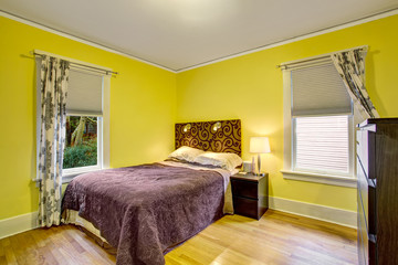 Bedroom interior with yellow walls and deep brown furniture