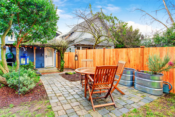 Obraz premium Patio z drewnianym zestawem stołowym i ładnym projektem krajobrazu