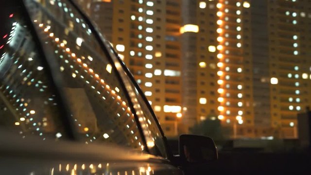 The car drive against the background of building. Evening night time. Real time 