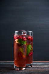 Raspberry cocktail with mint on the wooden background
