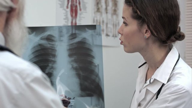 Doctor explaining x-ray results to senior patient.