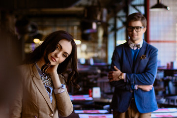 Man in glasses admires beautiful woman with long dark curls