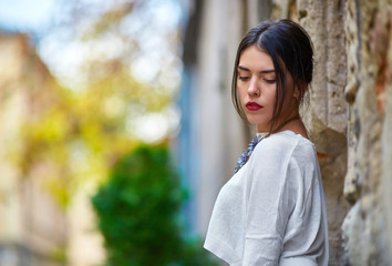 Attractive woman with red lips looks down while posing on the ol