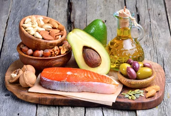 Poster Selection of healthy fat sources on wooden background. © craevschii