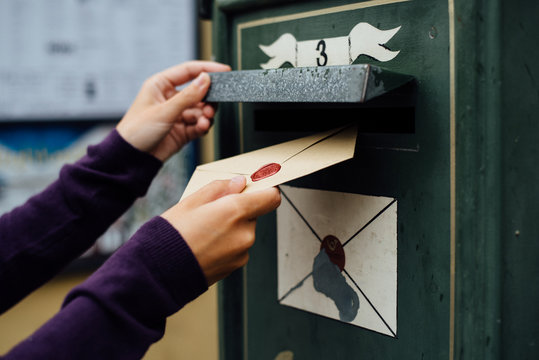 Posting letter to old postbox on street