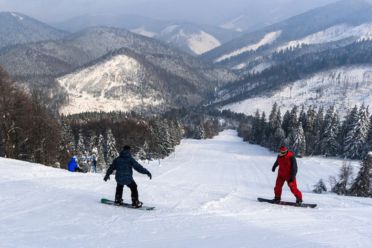 Snowboarders, descent from the mountain.