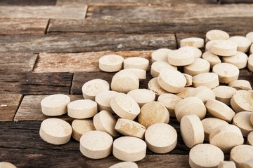 Fototapeta na wymiar Medicine pills on wooden background. Stock image macro.