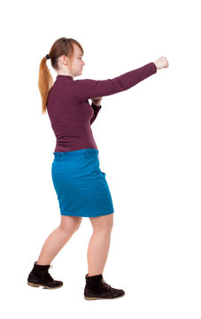 skinny woman funny fights waving his arms and legs. Isolated over white background. Girl with red hair tied in a pigtail boxing.
