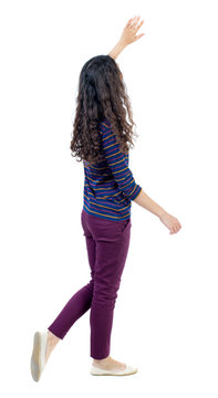 Back View Of Walking Woman Welcomes. Beautiful Girl Hand Waving From. Backside View Of Person.  Rear View People Collection. Isolated Over White Background. Long-haired Curly Girl Goes Past The Camera